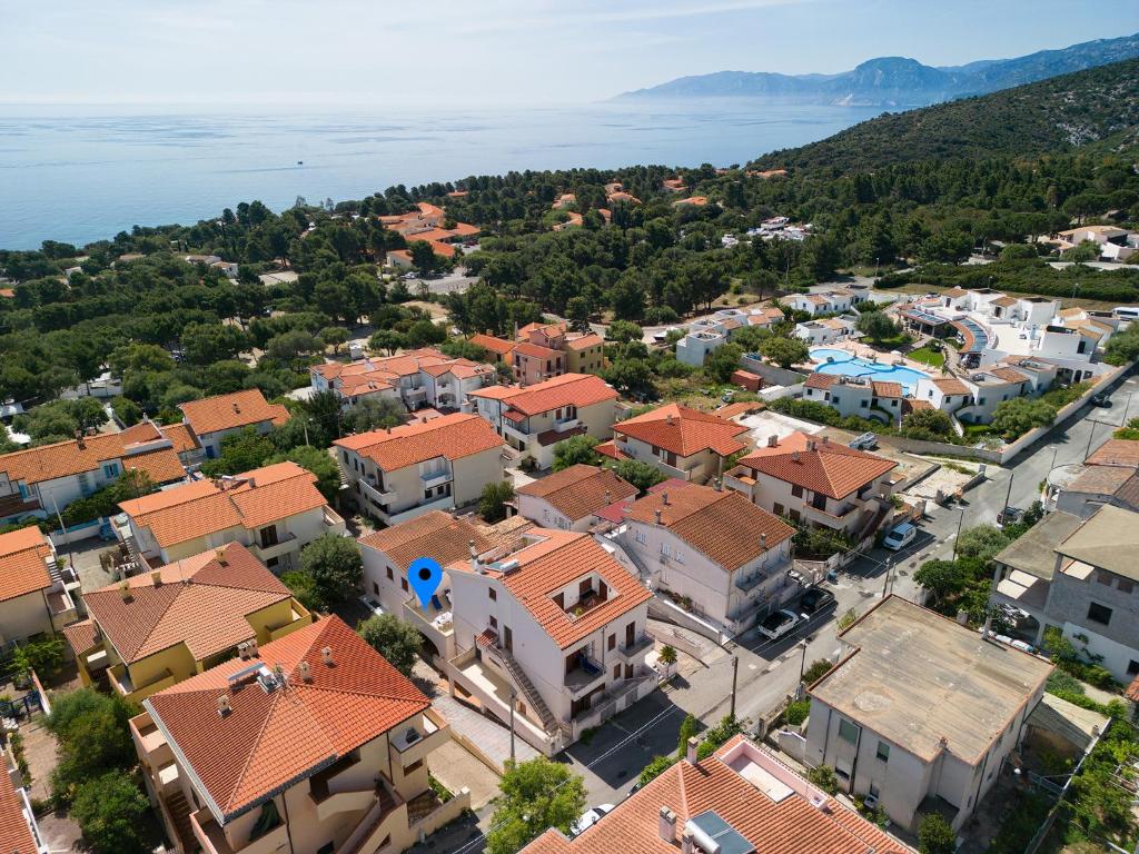 Spiaggia sarda con mare turchese e scogli vicino a un paese sul mare